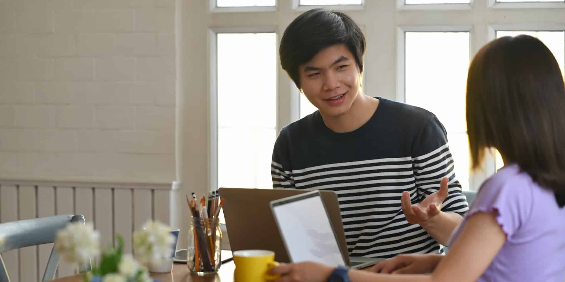 Two students talking at the kitchen table in a student landlord-owned property.